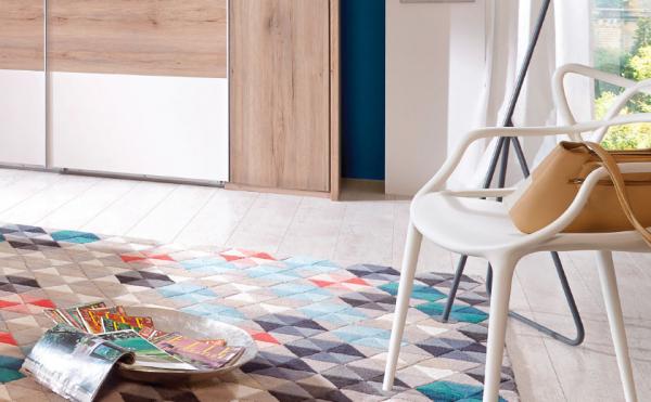 Priročen stol in pisana preproga v spalnici