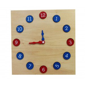 Ta prosto stoječa ura z gibljivimi rokami vsebuje številke, ki se lahko odstranijo iz utorov. Številke 1,3,6,9,12 so v rdeči barvi in ostale v modri barvi