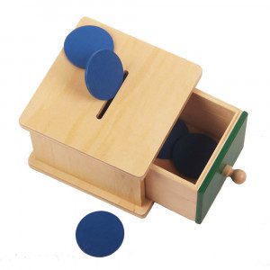 Material sestavlja 5 modrih žetonov in lesena škatla z režo. Otrok uporablja 3 prstni prijem, doživi izkušnjo stalnosti predmeta, vaje za fino motoriko.