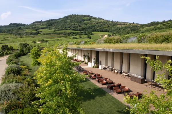 Nardi - Nardi vrtno pohištvo Soave, ItalijaKantina Pieropan Lokacija: Cantina Pieropan , Soave (VR), Italija Vinarija Pieropan v Soaveju, opremljena za večer z vrtnim pohištvom Nardi Za praznični večer je Nardi zagotovil svoje zunanje pohištvo za opremljanje zunanjega prostora vinarije Pieropan, arhitekturnega bisera, ugnezdenega v hribih Soave (VR). Lepo urejen in harmoničen projekt je vključeval ustvarjanje pravega salona pod zvezdami z Maximo, modularnim sistemom oblazinjenih sedežev, ki je bil za to priložnost konfiguriran kot dvosed z nizko mizico. Za srkanje kozarca vina ob občudovanju gričev so bili izbrani stoli Stack and Combo in visoke mize. Za ločevanje in razmejitev prostorov je bila uporabljena modularna pregrada Sipario. Vse pohištvo je izdelano iz regenerirane smole in tkanin z visoko vsebnostjo recikliranega materiala, izbranih za to priložnost v naravnih barvah Terra in Cannella, v skladu s konceptom vinarne in okoliško naravo. Izdelki: Maximo Poltrona , Maximo Tavolino , Stack Maxi , Combo , Sipario
