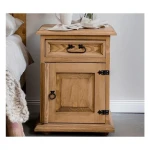 Nočna omarica POP leva . Nočna omarica POP leva je narejena iz kvalitetnega borovega lesa v medeno rjavi barvi. Ta omarica ustreza levi postavitvi. Material: