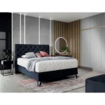 Postelja KORI je narejena iz robustnega okvirja s črnimi kovinskimi nogami višine 15 cm. Prešito vzglavje je polnjeno s peno, ki zagotavlja mehko oporo za