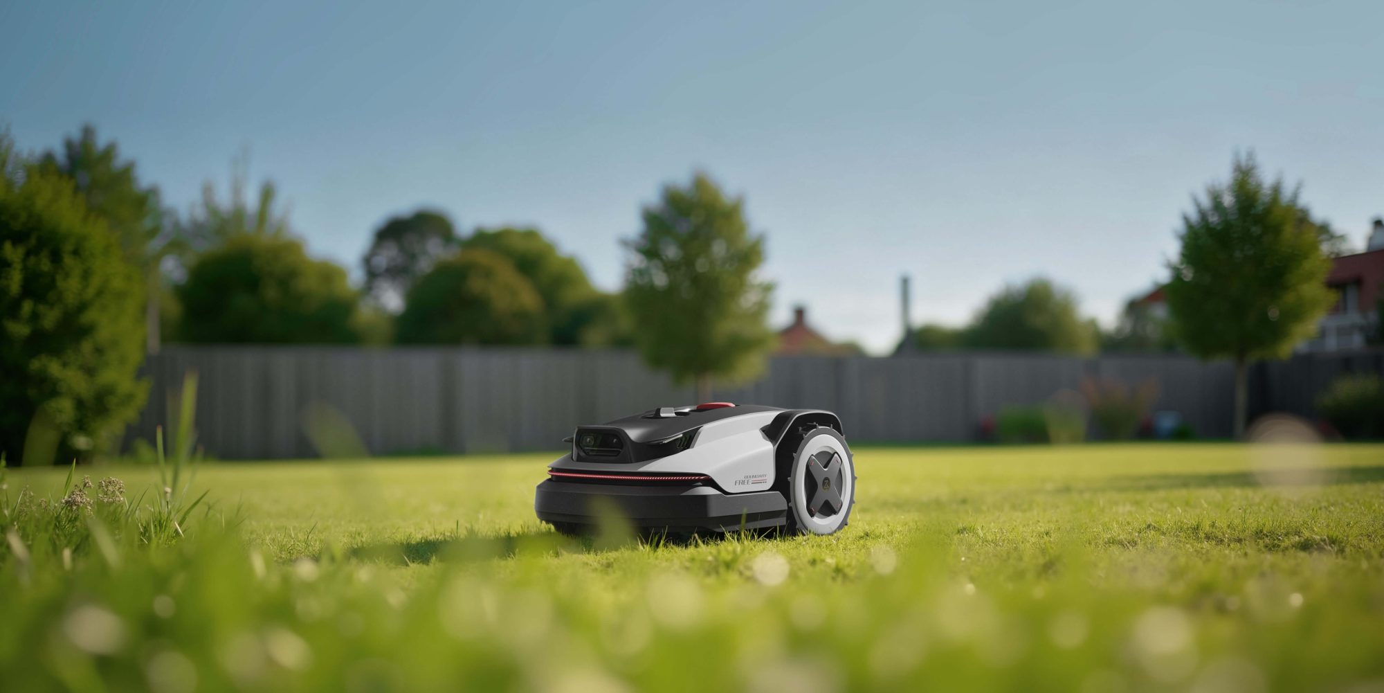 Roborock RockNeo Q1 na sončni trati z drevesi in leseno ograjo v ozadju